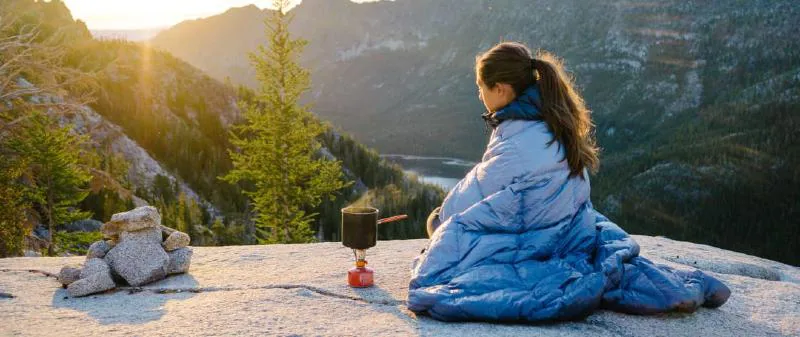 Rumpl Blanket Original Outdoor Blanket around a woman in the mountains 